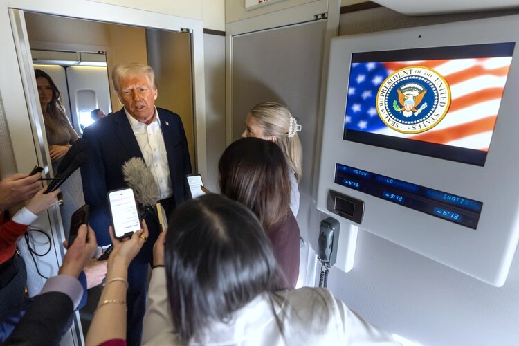 Donald Trump habla con reporteros a bordo del Air Force One, este 25 de enero.
