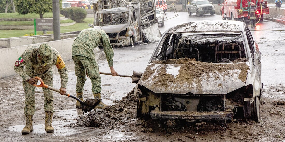 Militares enfrían un auto incendiado, el 10 de septiembre.