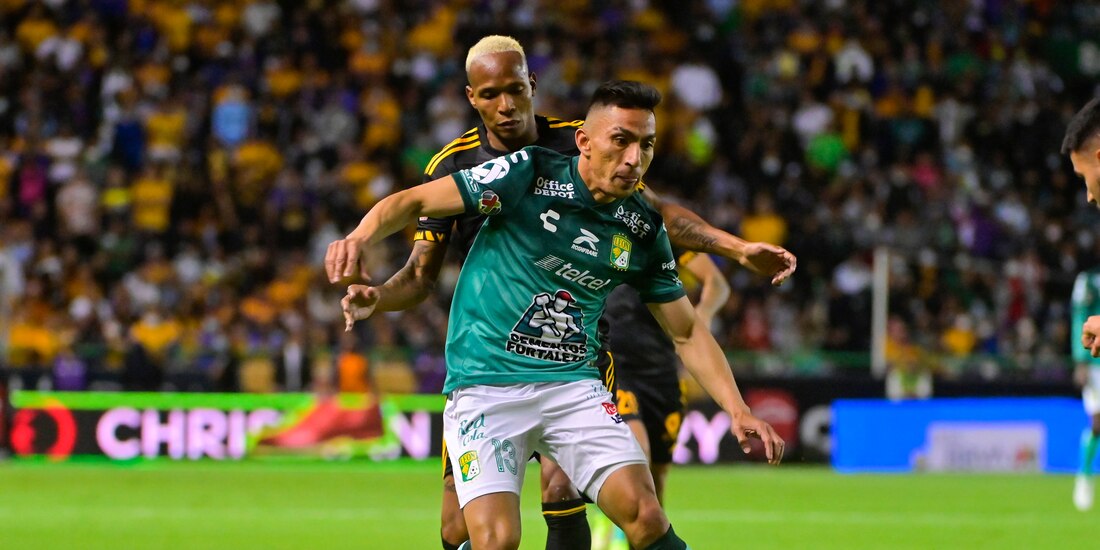 Ángel Mena retiene el balón ante la presión de Luis Quiñones, en la semifinal de vuelta entre León y Tigres.