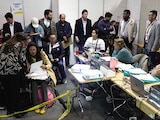 Funcionarios y observadores asisten al recuento oficial, en Bogotá, el lunes.