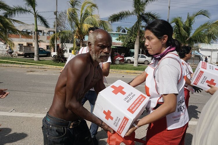 Voluntarios de la Cruz Roja Mexicana entregaron ayuda humanitaria a cientos de familias en inmediaciones de la Glorieta del Puerto Marqués, en Acapulco, ayer.