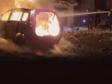 Un rescatista apaga el incendio de un automóvil dañado por un ataque ruso en la región de Sumy, Ucrania, ayer.