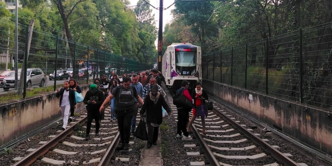 Usuarios caminan entre las vías del Tren Ligero por falla en el servicio.