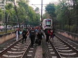 Usuarios caminan entre las vías del Tren Ligero por falla en el servicio.