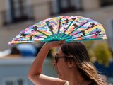 Una mujer se protege del rayo de sol con su abanico, ante el calor en España, ayer.