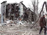 Un hombre camina cerca de un edificio residencial destruido durante el conflicto Ucrania-Rusia en la ciudad portuaria de Mariupol.