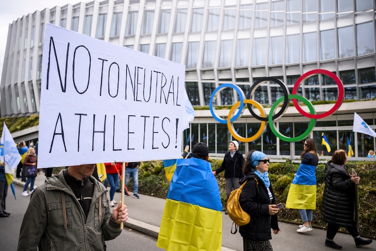 Miembros de la rama de Ginebra de la sociedad ucraniana en Suiza protestan durante una manifestación para instar al COI a reconsiderar su decisión de participación de atletas rusos y bielorrusos en París 2024.