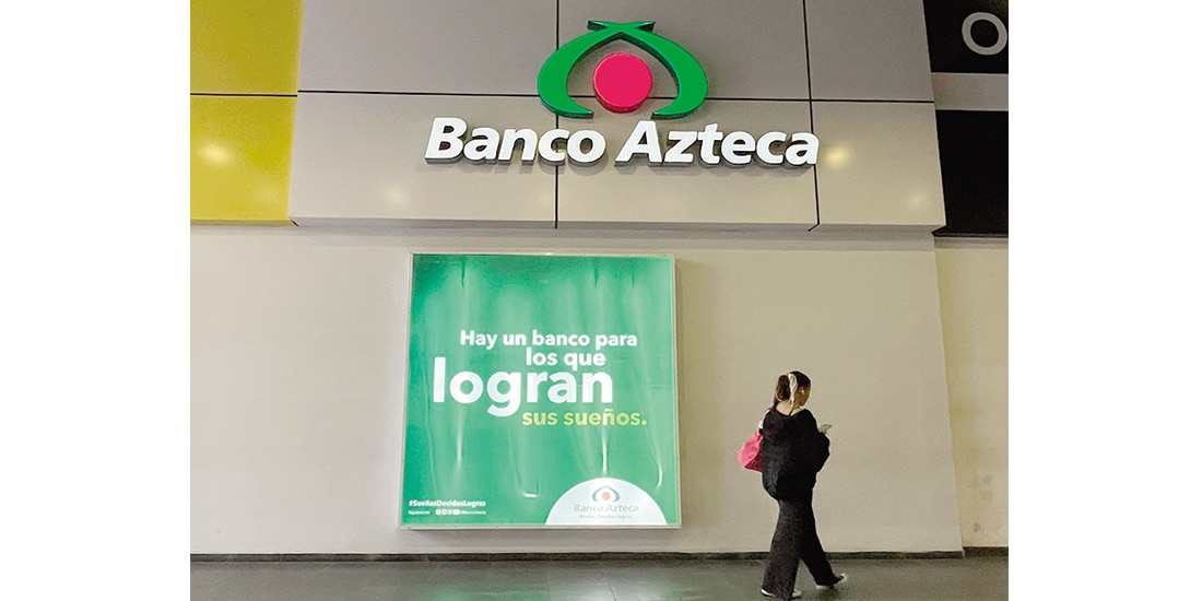 UNA MUJER camina frente a una sucursal de Banco Azteca, el 20 de enero.
