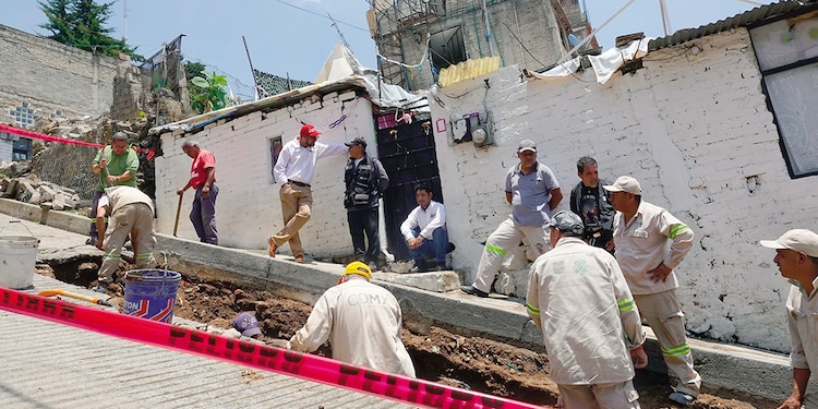 Trabajadores del Gobierno local reparan la calle afectada por el caudal, ayer.