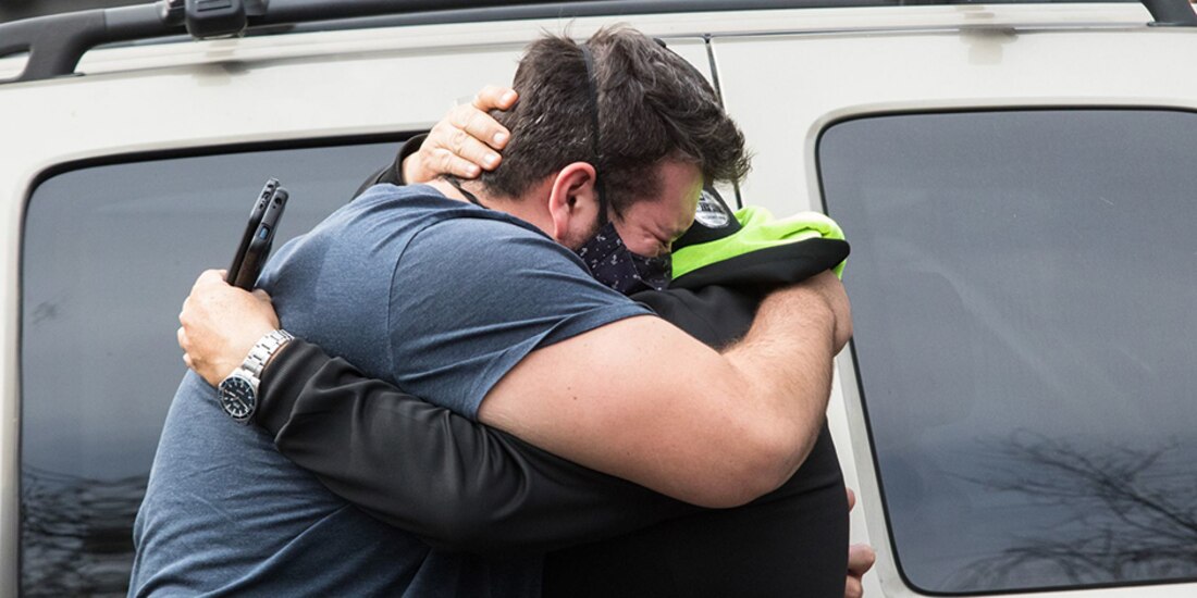 Un par de hombres lloran tras recibir noticias de su familiar ingresado en el área de urgencias respiratorios del Hospital de los Venados.