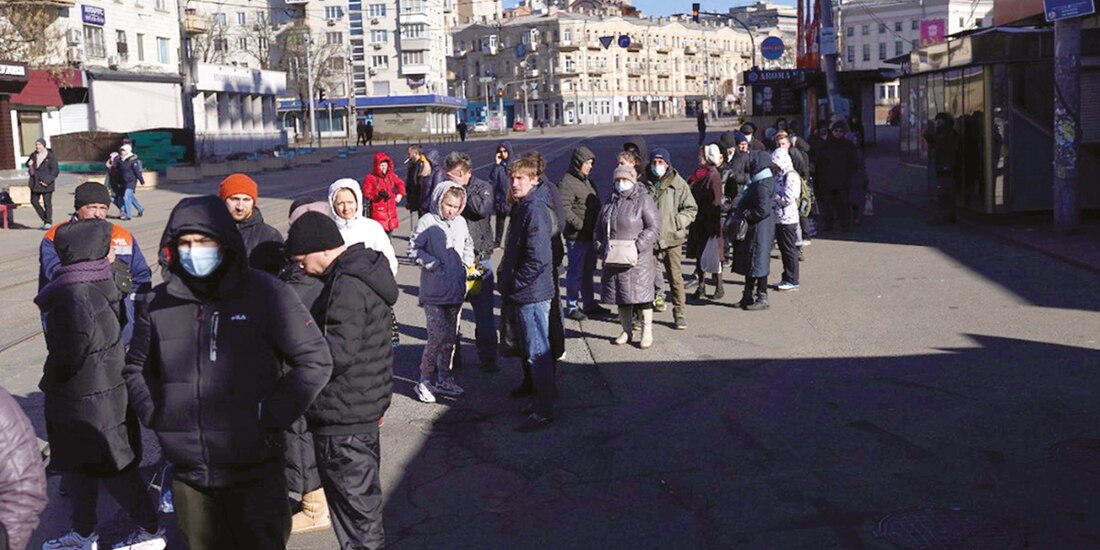 Decenas de personas se conglomeran a las afueras de un banco en Moscú.
