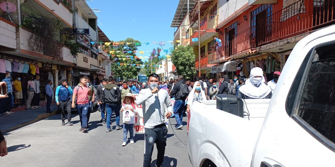 Un estudiante normalista avanza del contingente sosteniendo un micrófono para lanzar consignas.