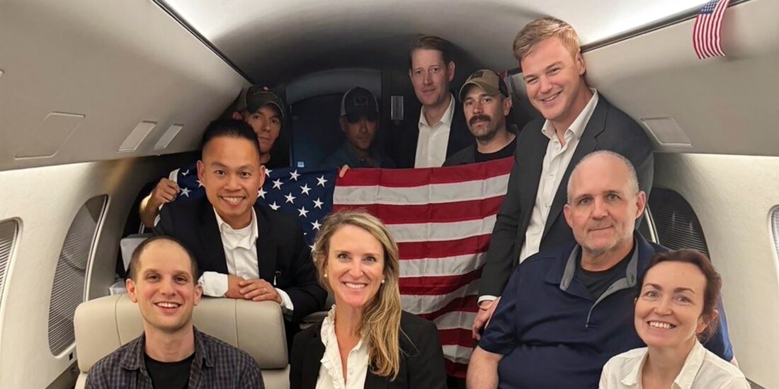 El periodista Ewan Gershkovich (izq.) viaja con otros exprisioneros tras pasar años detenido en Moscú.