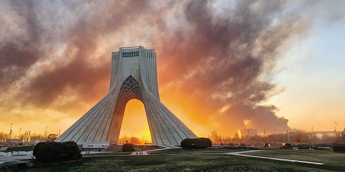 Humo se eleva detrás de la Torre de la Libertad, tras un ataque militar en Teherán, ayer.
