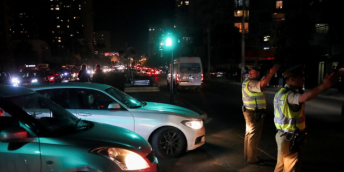 Policías ayudan a agilizar el tránsito en medio de la oscuridad por el apagón masivo de ayer.