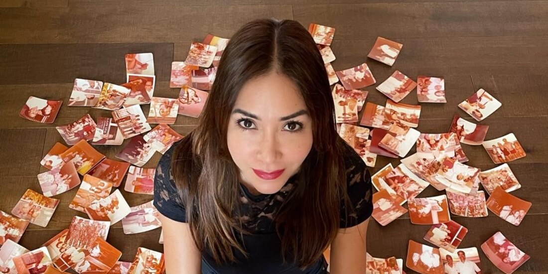 la narradora Ligia Urroz posa con un ejemplar de su novela y decenas
de fotografías de su infancia.