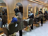En esta imagen de archivo, varias empleadas maquillan a clientas en el salón de belleza Ms. Sadat, en Kabul, Afganistán, el 25 de abril de 2021.