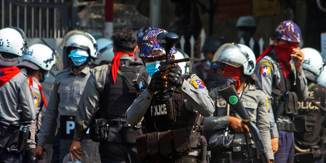 Un oficial de la policía antidisturbios dispara una bala de goma hacia los manifestantes