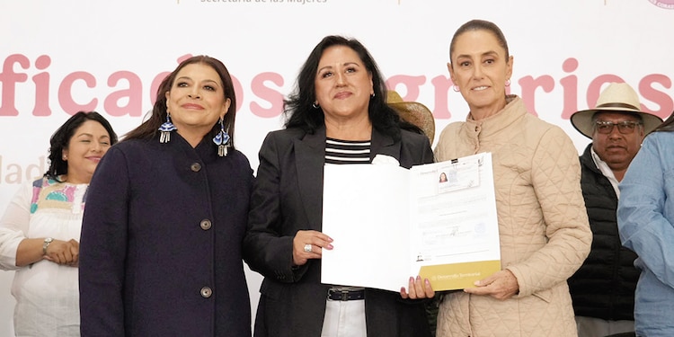 Claudia Sheinbaum (der.) y Clara Brugada, ayer, al entregar su título a una beneficiaria (c.).