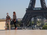 Transeúntes con mascarillas caminan frente a la Torre Eiffel, en Paris, Francia.