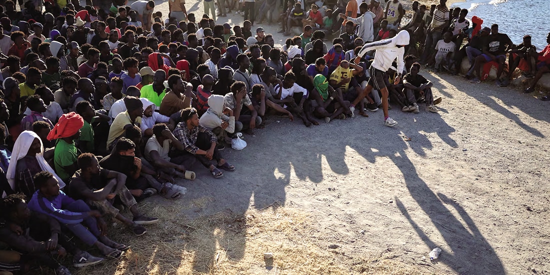 Migrantes esperan a recibir comida, ayer, en Ceuta.