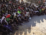 Migrantes esperan a recibir comida, ayer, en Ceuta.