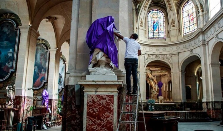 Las imágenes y figuras en la iglesia se cubren con mantos morados en Semana Santa.