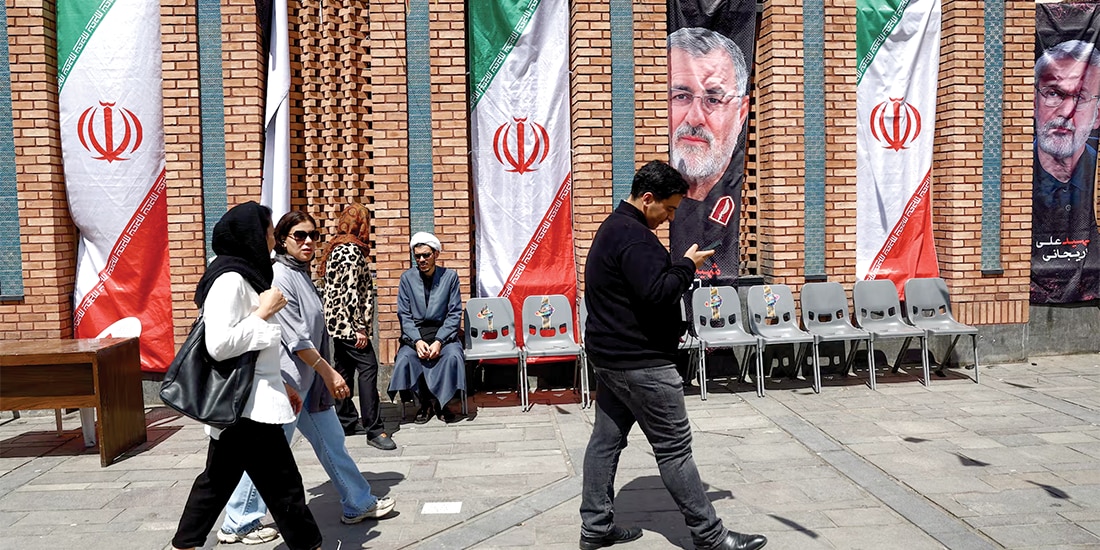 PERSONAS caminan por una calle de Teherán, el 20 de abril.