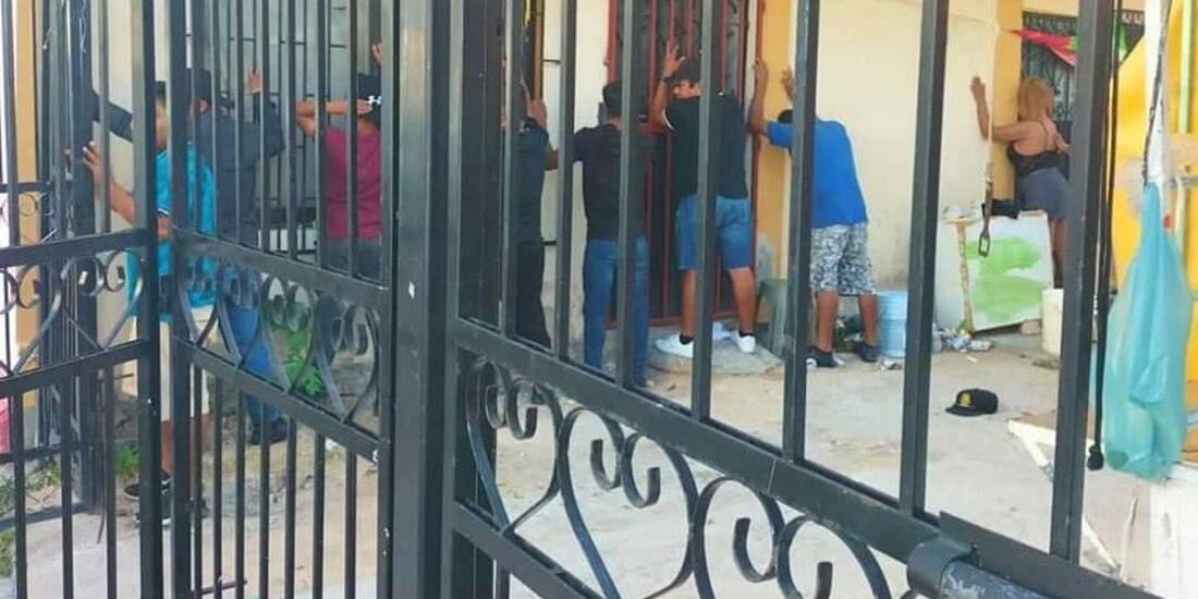 Varios adultos fueron puestos contra la pared para ser revisados durante el cateo realizado en una vecindad de Playa del Carmen en donde estaban los menores, ayer.