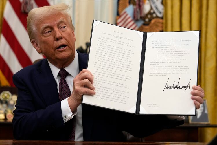El presidente Trump muestra una orden ejecutiva firmada en la Casa Blanca.