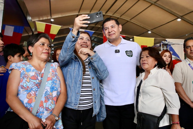Gobernador Alejandro Armenta se toma una fotografía con asistentes a la Feria de Puebla.