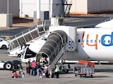 VIAJEROS abordan un avión de Flydubai en el Aeropuerto Internacional Ben Gurion, ayer.