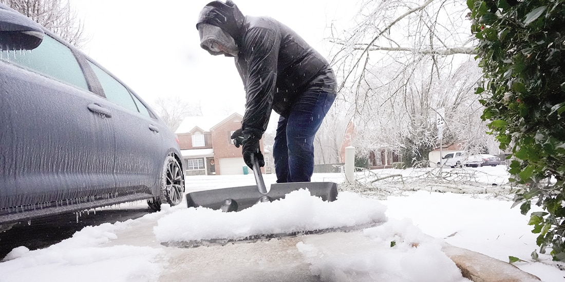 Una imagen de AP en la que se muestra a una persona barriendo la grandes cantidades de nieve, ayer.