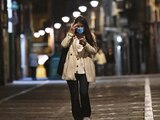 Una mujer con cubrebocas camina por una calle vacía de, Pamplona, en el norte de España, ayer.