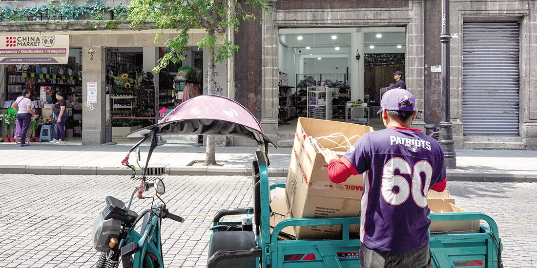 Un trabajador dobla cajas de cartón de focos led en su vehículo, ayer, frente a una tienda asiática.