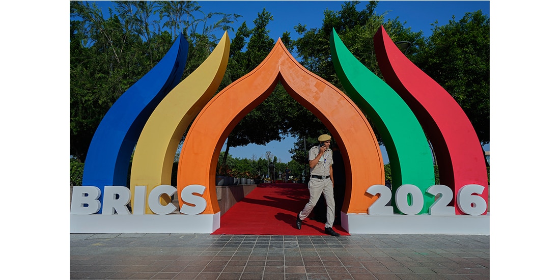 Un agente de policía pasa junto a un símbolo de los BRICS que representa una flor de loto en Bharat Mandapam, la sede principal de la cumbre, en Nueva Delhi, India, el domingo 13 de septiembre de 2026.