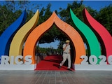 Un agente de policía pasa junto a un símbolo de los BRICS que representa una flor de loto en Bharat Mandapam, la sede principal de la cumbre, en Nueva Delhi, India, el domingo 13 de septiembre de 2026.