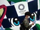 Un hombre camina frente a un anuncio de los Juegos Olímpicos de Tokio 2020 en la capital de Japón.