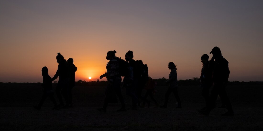 Migrantes caminan en Peñitas, Texas.