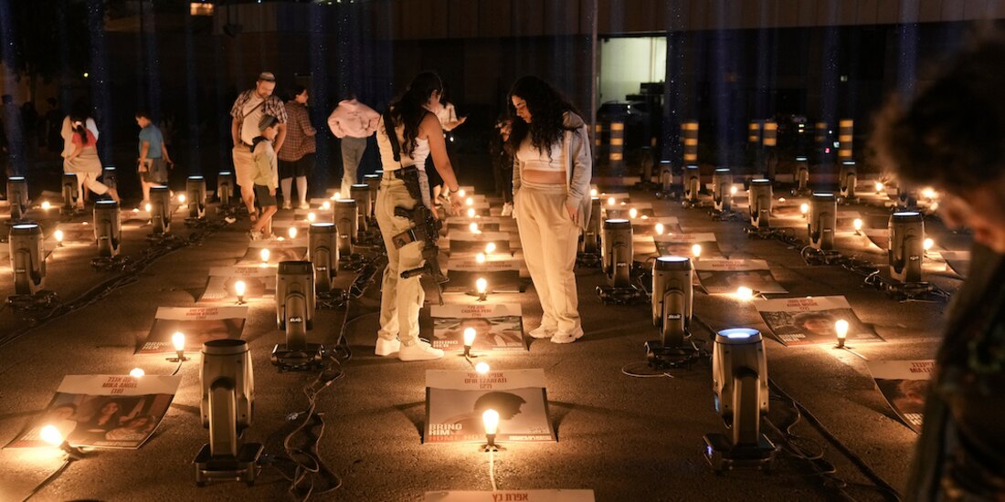 Pobladores de Jerusalén muestran las fotografías de los rehenes en solidaridad con las familias, ayer.