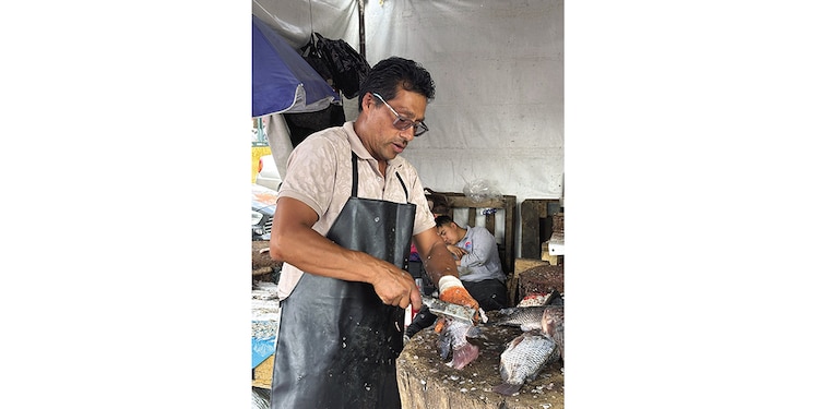 Filetero limpia pescado en un puesto autorizado en la Nueva Viga, ayer.