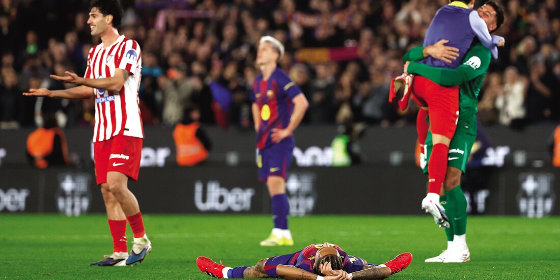 Raphinha yace en el césped, mientras jugadores del Atlético festejan, ayer.