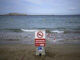 Un cartel anuncia que está prohibido entrar a nadar en la playa tras el paso de una tormenta en Marsella, Francia.