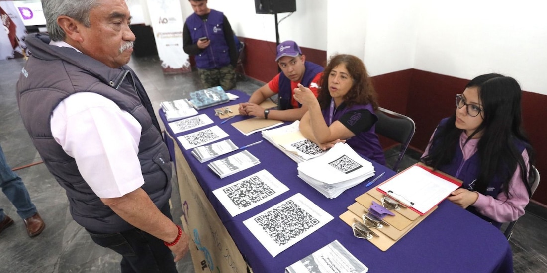 Personal del IECM atiende a un hombre durante la recepción de peroyectos de Presupuesto Participativo.