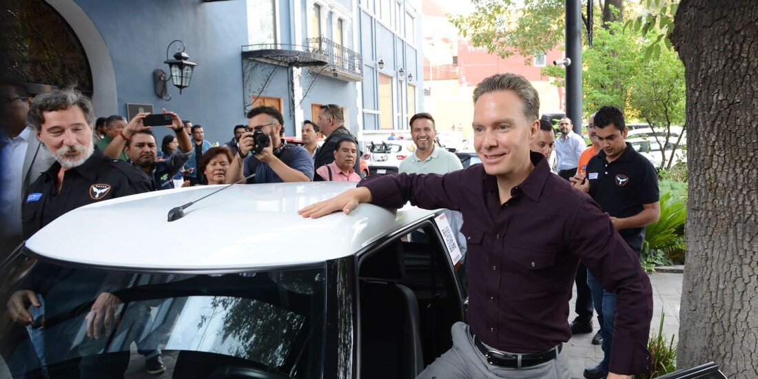 El aspirante, con un auto eléctrico, ayer.