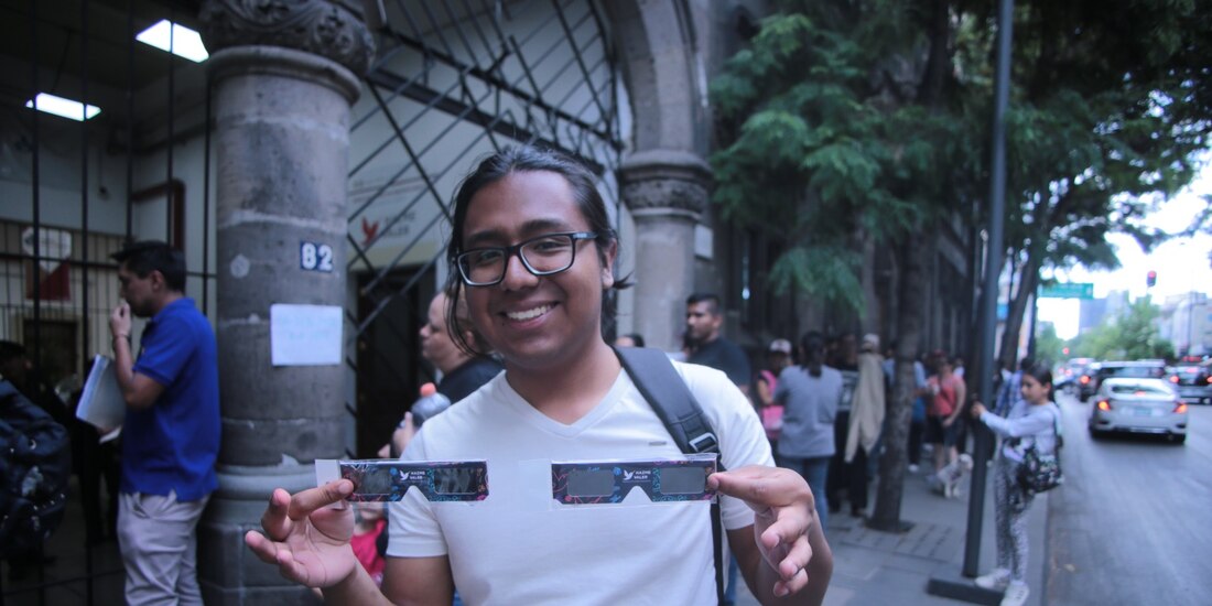 Una persona muestra sus lentes con los que podrá ver el eclipse de sol.