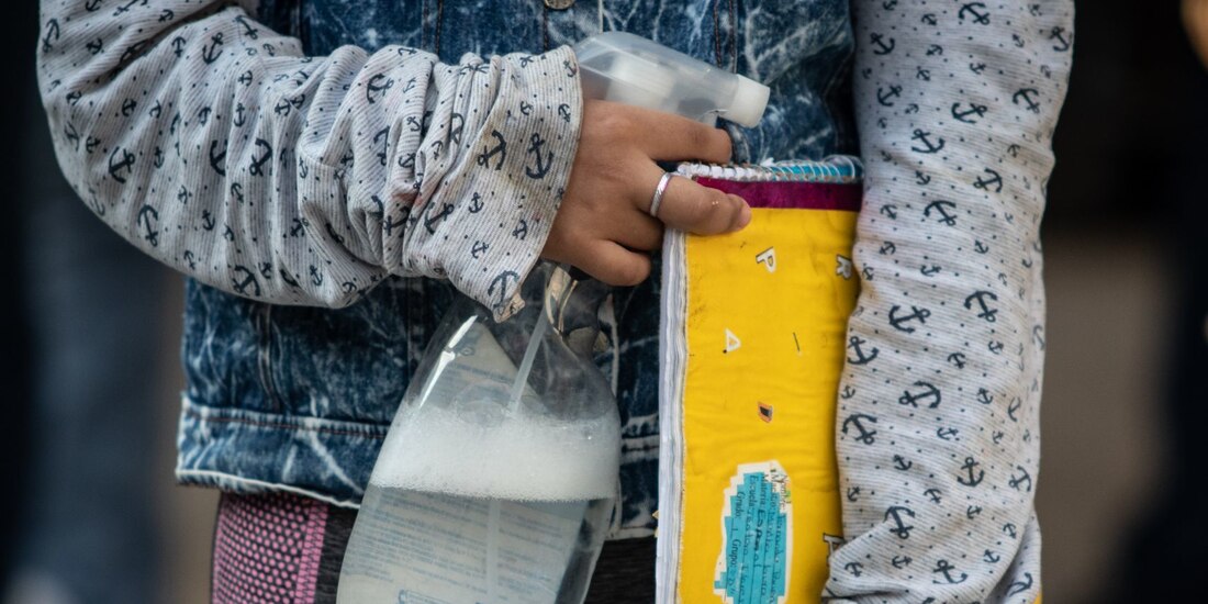 Una alumna de secundaria carga con instrumentos desinfectantes para evitar contagios por COVID-19 en su regreso a clases presenciales.