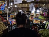 Una mujer revisa los precios de venta de un mercado.