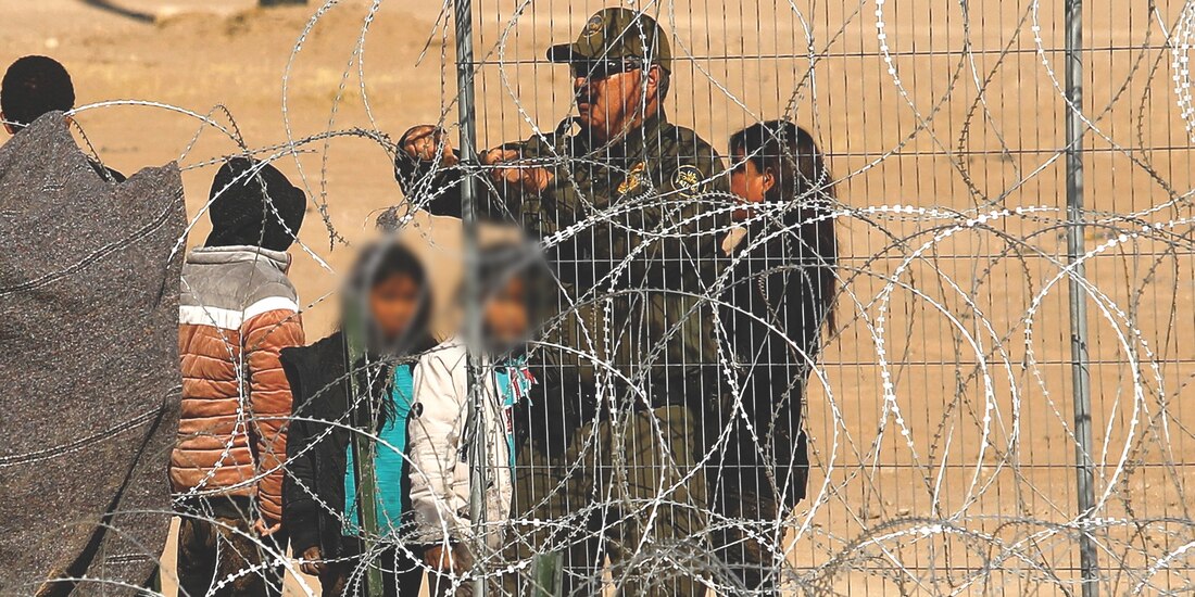 Un agente de la Patrulla Fronteriza junto a migrantes, en Ciudad Juárez, el 22 de enero.