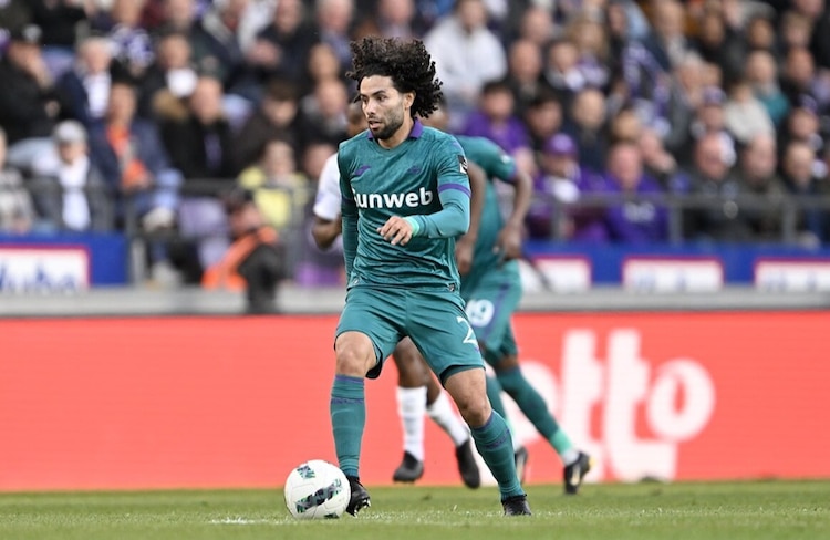 César Huerta conduce el balón en el juego en Lotto Park, en Bélgica